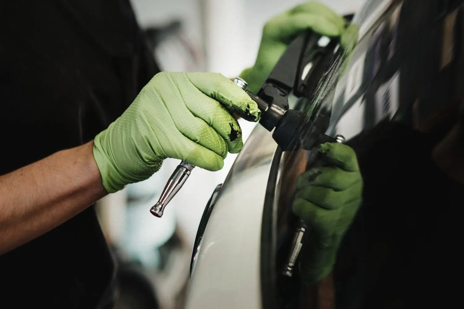 Technician using spray equipment for car bodywork refinishing